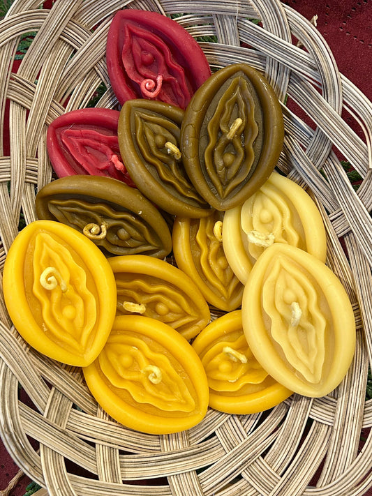 Colorful vagina shaped beeswax candles on a woven basket