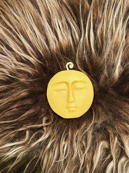 Beeswax moon candle on brown sheepskin.