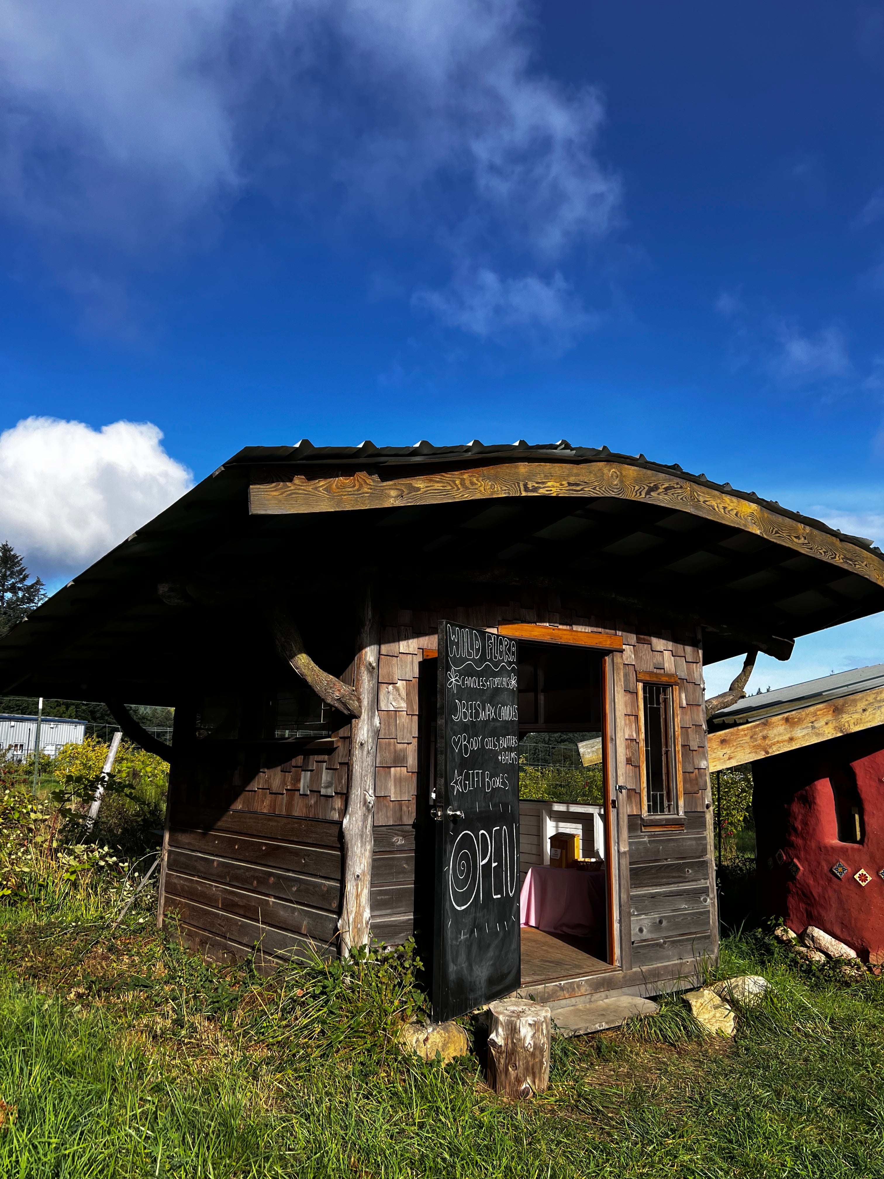 Wooden farmstand on a grassy area with a blue sky